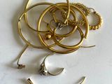 a pile of gold jewelry on a white surface