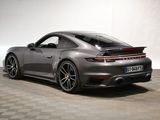 a grey porsche 911 gts parked on a checkered floor