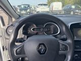 a steering wheel and dashboard of a car in a parking lot