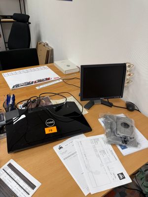 un bureau sur lequel se trouvent un ordinateur portable, un écran et d'autres objets