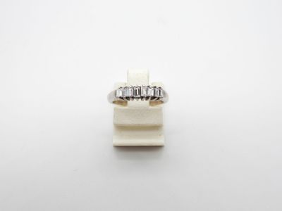 a close up of a diamond ring on a white surface