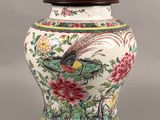 a vase with a bird on it sitting on a table