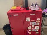 a red locker with a bunch of items on top of it
