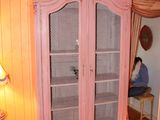 a pink cabinet in the corner of a room