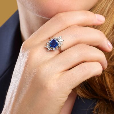 an image of a woman wearing a blue sapphire and diamond ring