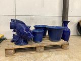 many blue vases sitting on a pallet next to each other