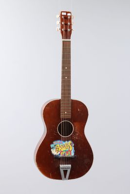 an image of a guitar hanging from a string on a wall