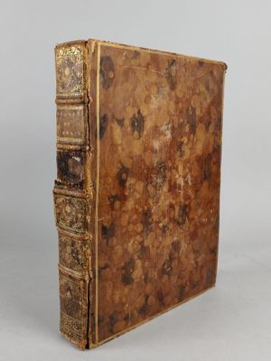 an old book sitting on top of a table next to a white wall