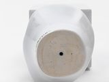 a white vase that has a hole in the middle of it