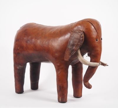un petit éléphant en bois posé sur une surface blanche