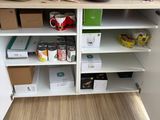 a cupboard with many items on it in the kitchen