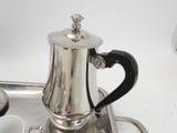 a silver coffee pot sitting on top of a silver tray