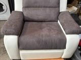 grey and white reclining chair in a garage with a washing machine in the background