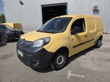 the small yellow van is parked in front of a building