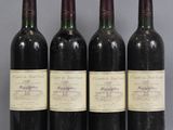 three bottles of wine are lined up on a table