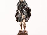 statue of a man in a black coat holding a bag
