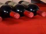 several bottles of wine are lined up on a red cloth