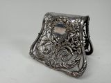 un porte-monnaie ancien en argent orné d'une pierre au centre