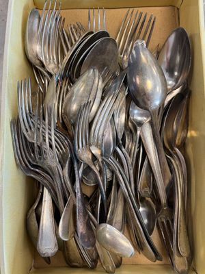 a lot of silver spoons and forks in a box