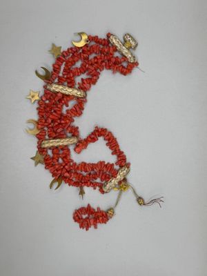 un collier de perles rouges orné d'un dragon en or