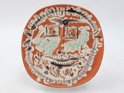 a plate with a face on it on a white surface