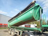 a large green dump truck with a large green container on the back