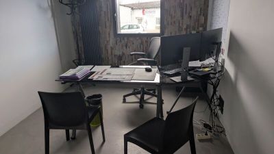 a desk with two computers and a chair in a room