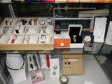 a glass display case filled with watches and other items