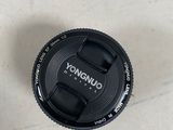 a black camera lens sitting on the floor next to a cup of coffee
