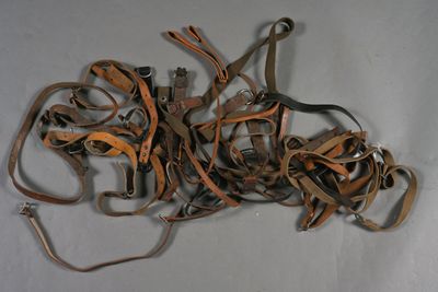 un tas d'objets en cuir et en métal posés sur une surface blanche