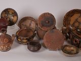 many different types of pottery on display on a white surface