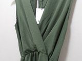 the back of a green dress hanging on a hanger