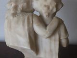 a statue of two children hugging each other on a table