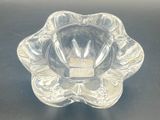 a clear glass bowl on a table with a black background