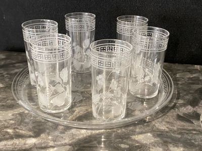 six glasses sitting on a glass tray on a table