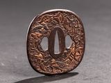 a small metal object that looks like a tsuba