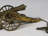 a small brass cannon sitting on a white surface