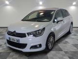 la voiture blanche est garée sur un sol en damier dans le garage