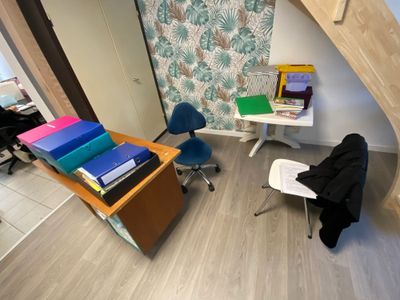 a room with a desk, chair, and bookshelf in it