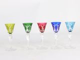 four different colored wine glasses are lined up in a row