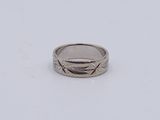 gros plan d'une bague en argent sur une surface blanche