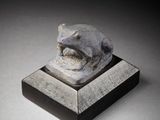 sculpture of a cat on a pedestal with a black background