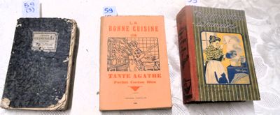 Trois livres sont alignés sur une table recouverte d'une nappe blanche.