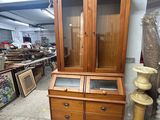 une armoire en bois avec deux tiroirs et une porte vitrée