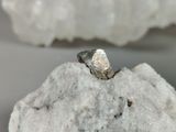 a silver ring sitting on top of a piece of rock