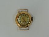 a small gold watch on a white surface