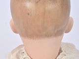 a close up of a doll ' s head with a sweater on
