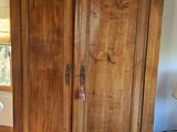 a large wooden armoire in the corner of a room