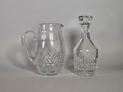 un pichet en verre et une bouteille en verre posés l'un à côté de l'autre
