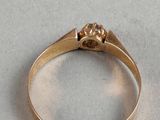 a close up of a gold ring on a white surface